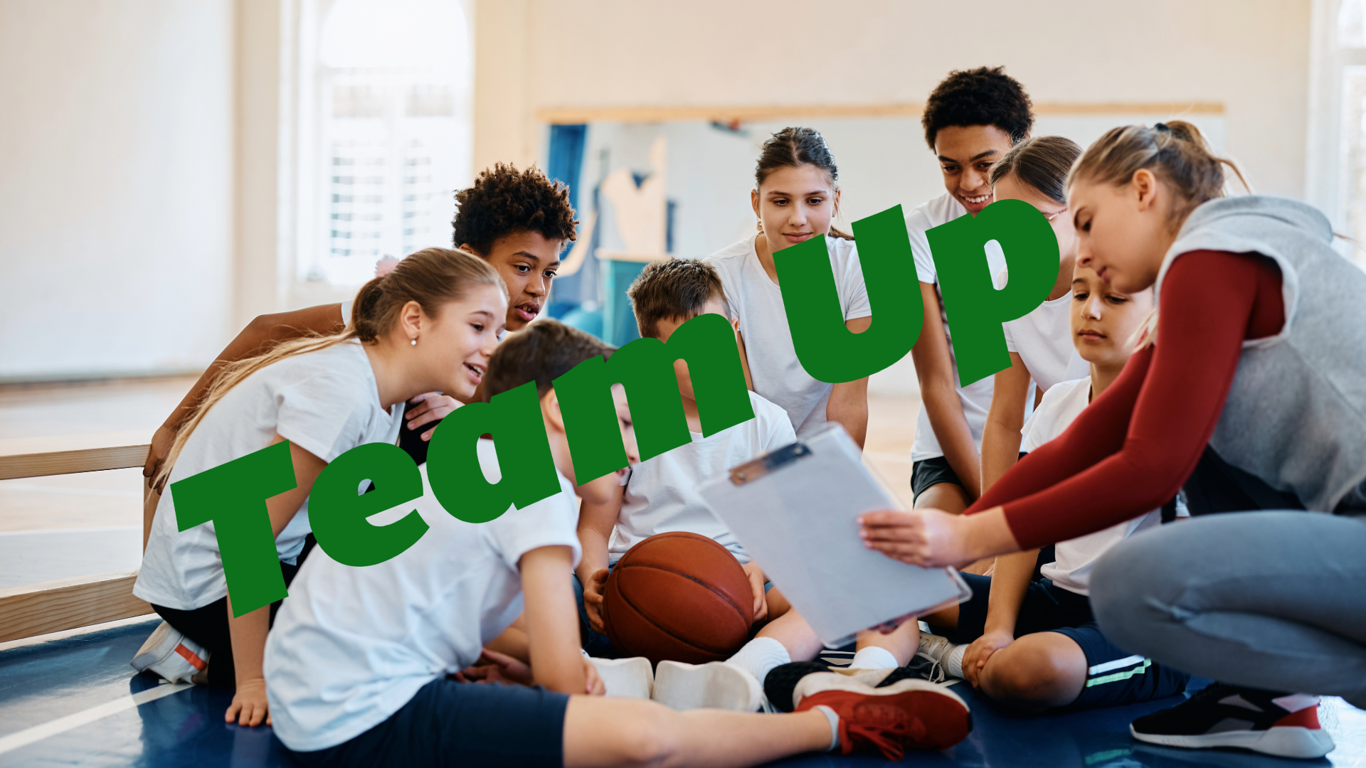 Team of young basketball players huddled together with their coach